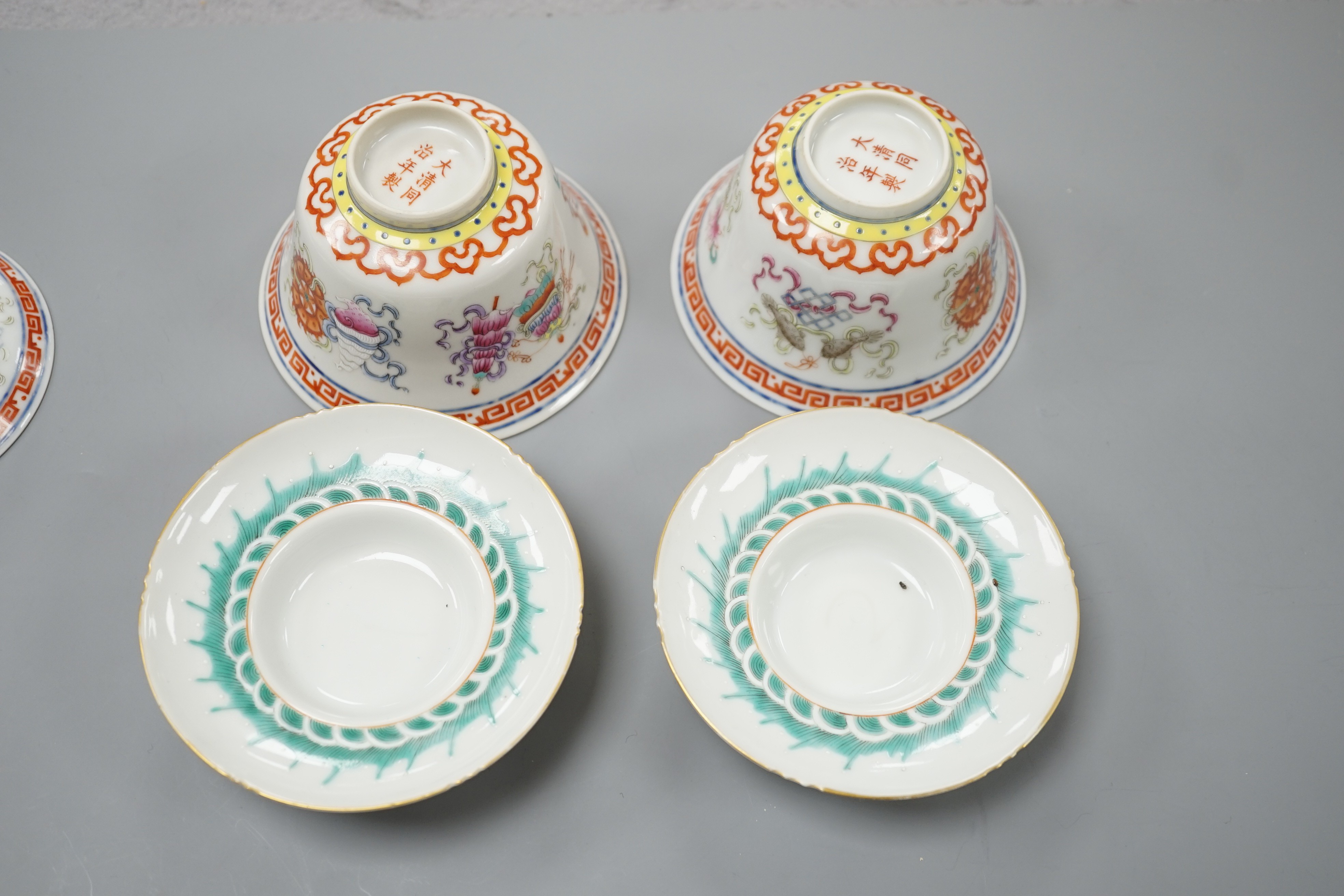 A pair of Chinese famille rose bowls, covers and stands painted with the 8 Buddhist emblems, 9cm total height